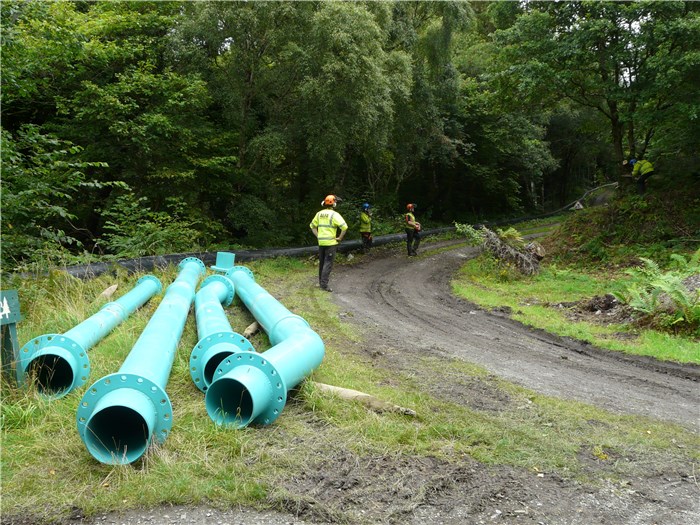 Steel pipe ready for installation down the slope to the turbine house and Alfa Tree Services carrying out some final clearance 24 Aug 2015